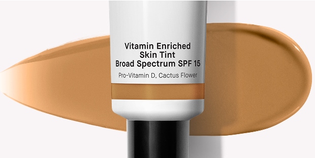 Close up of Vitamin Enriched Face Base with swatch behind over a pale blue background